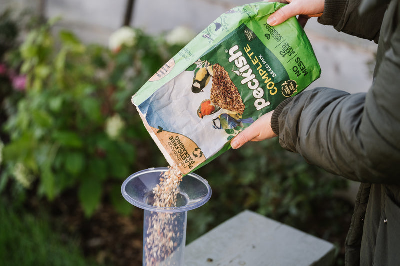 Peckish complete seed mix being poured into feeder